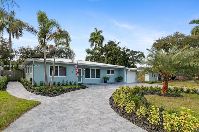 single story home with a garage and a front lawn