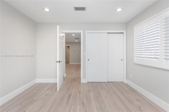 unfurnished bedroom featuring a closet and light wood-type flooring