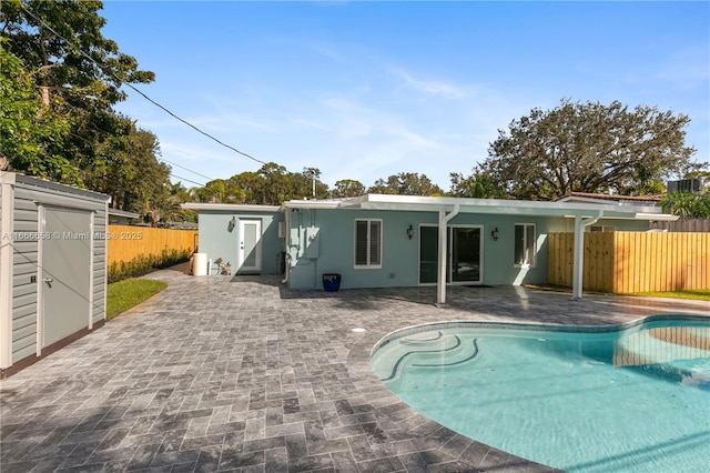 back of house with a fenced in pool and a patio