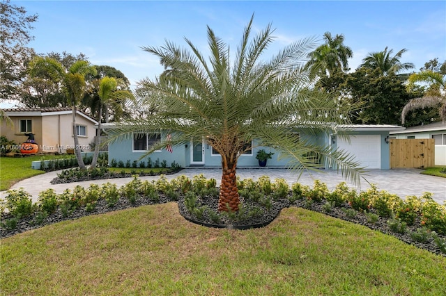 view of front of house featuring a garage and a front lawn