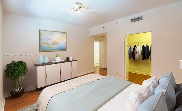 bedroom featuring hardwood / wood-style flooring, a closet, and a walk in closet