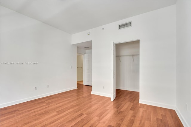 unfurnished bedroom featuring light hardwood / wood-style floors and a closet