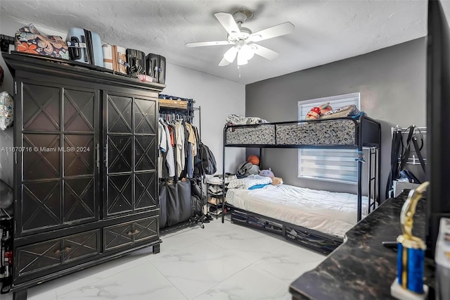 bedroom with ceiling fan and a textured ceiling