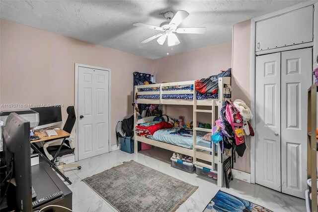 bedroom with ceiling fan and a textured ceiling