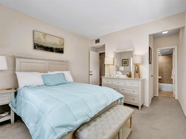 bedroom with light carpet and ensuite bath