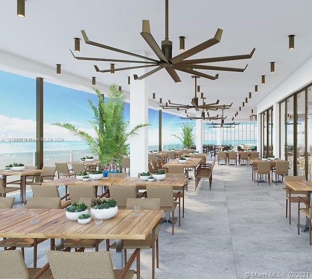 dining space with a water view, plenty of natural light, and an inviting chandelier