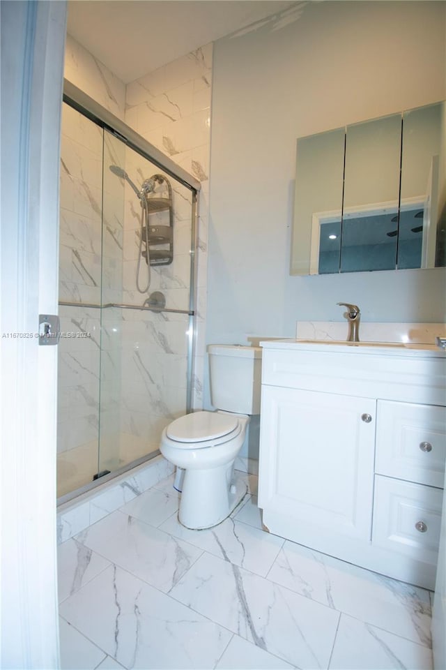 bathroom with vanity, toilet, and a shower with shower door