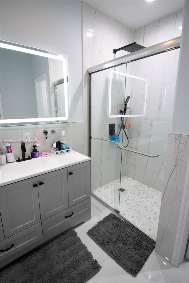 bathroom featuring tile walls, vanity, and a shower with shower door