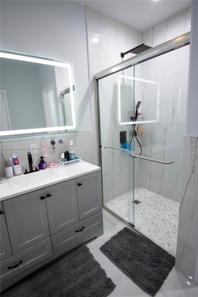 bathroom featuring walk in shower, tile walls, vanity, and tile patterned floors