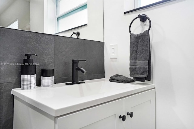 bathroom featuring vanity and tasteful backsplash