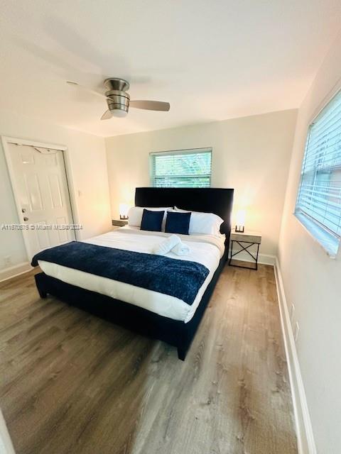 bedroom featuring hardwood / wood-style floors, multiple windows, and ceiling fan