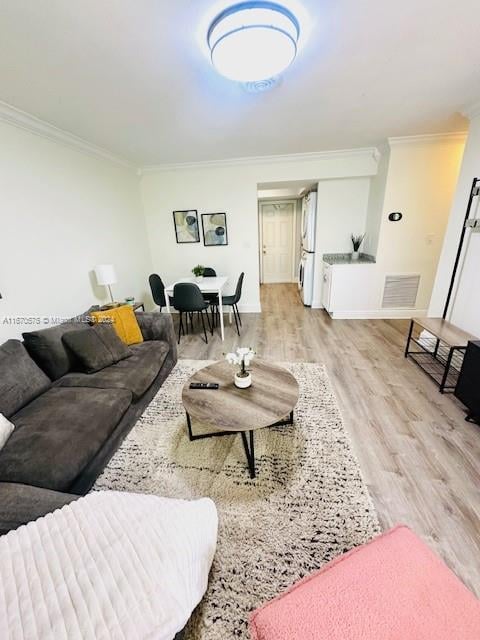 living room featuring light wood-type flooring and crown molding