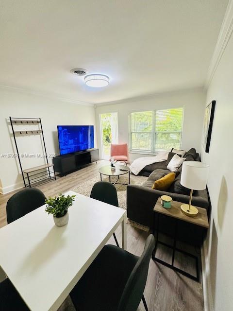 living room with light hardwood / wood-style flooring and ornamental molding