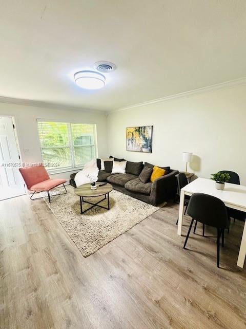 living room with light hardwood / wood-style flooring and ornamental molding