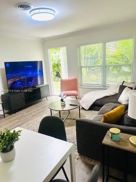 living room with hardwood / wood-style flooring and crown molding