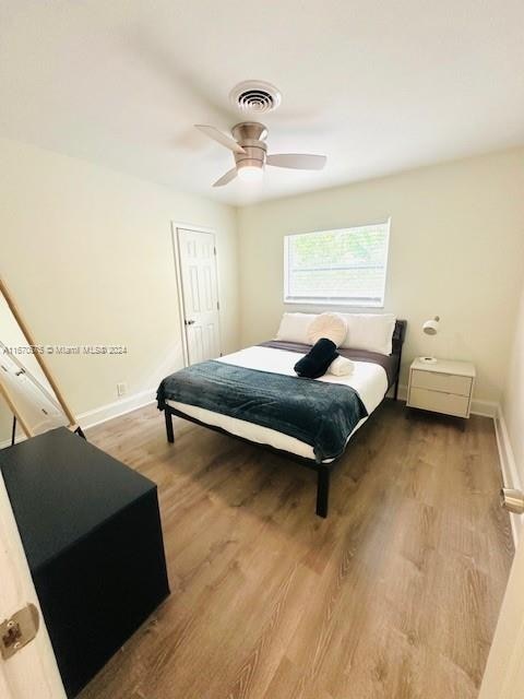 bedroom featuring wood-type flooring, a closet, and ceiling fan