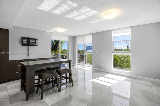 tiled dining space featuring a textured ceiling