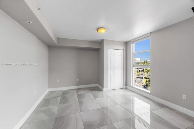 unfurnished bedroom featuring light tile patterned flooring and a closet