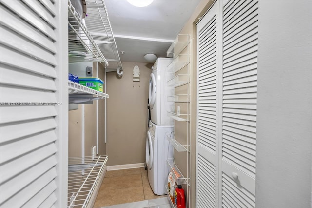 laundry room featuring light tile patterned floors and stacked washing maching and dryer