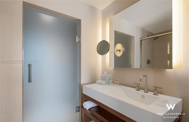 bathroom featuring tile walls, vanity, and an enclosed shower