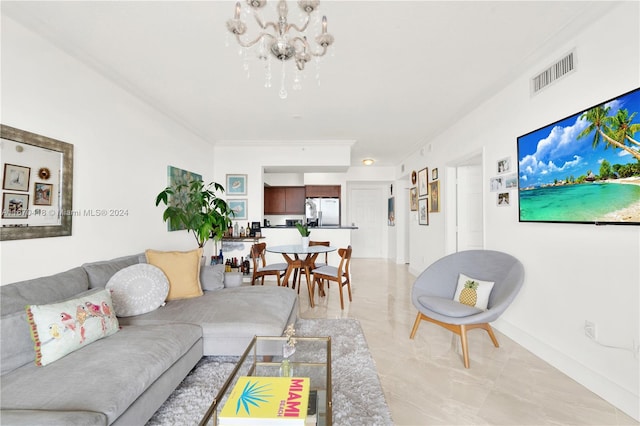 living room with crown molding and an inviting chandelier