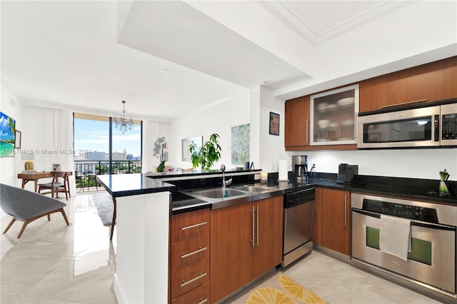 kitchen featuring sink, kitchen peninsula, stainless steel appliances, crown molding, and a chandelier