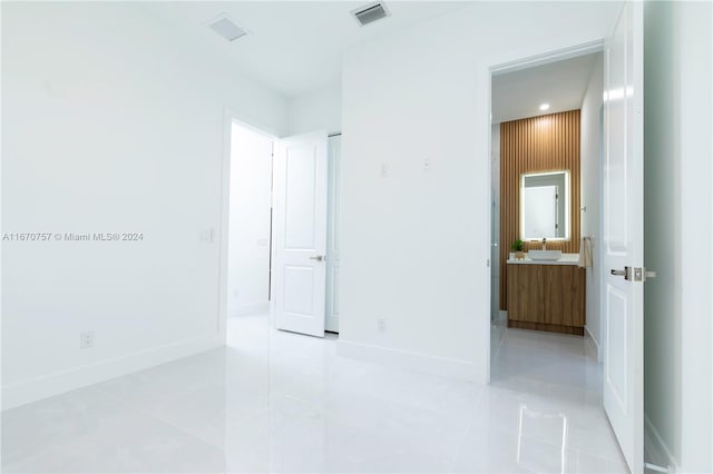 interior space featuring connected bathroom and light tile patterned floors