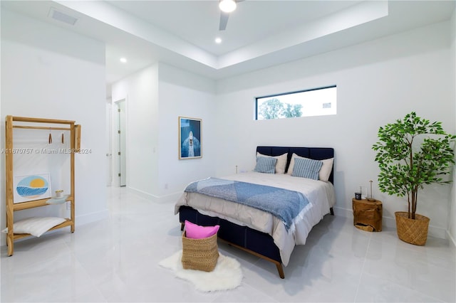 bedroom with light tile patterned flooring, a raised ceiling, and ceiling fan