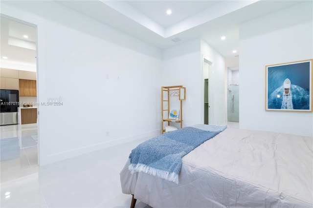 bedroom featuring connected bathroom and stainless steel fridge