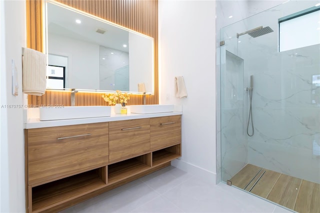 bathroom featuring vanity, tile patterned flooring, and a tile shower