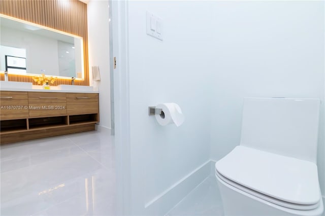 bathroom featuring vanity, tile patterned flooring, and toilet