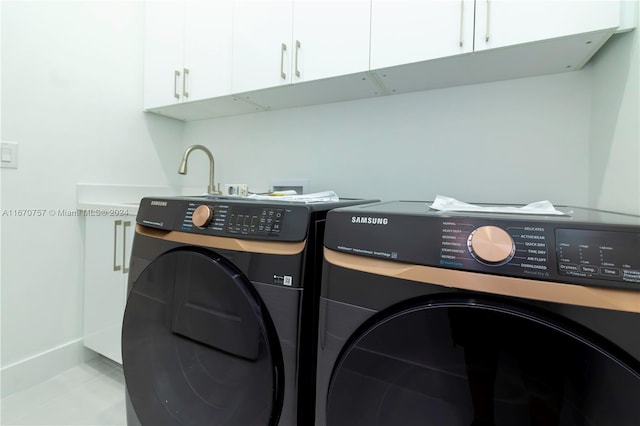 laundry room with washing machine and dryer and cabinets