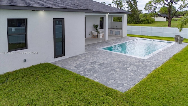 view of pool featuring a patio and a yard