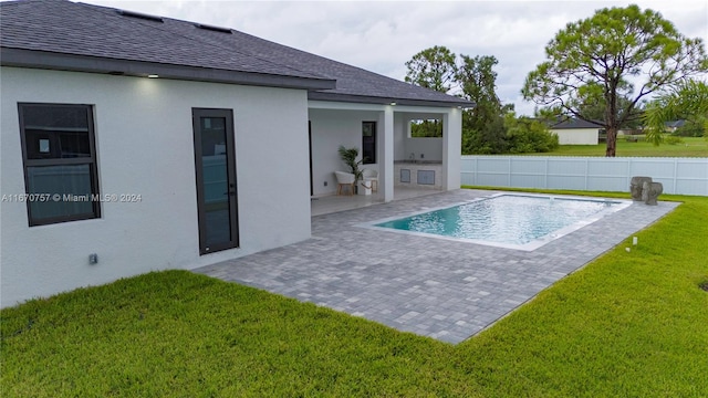 view of pool with a lawn and a patio area