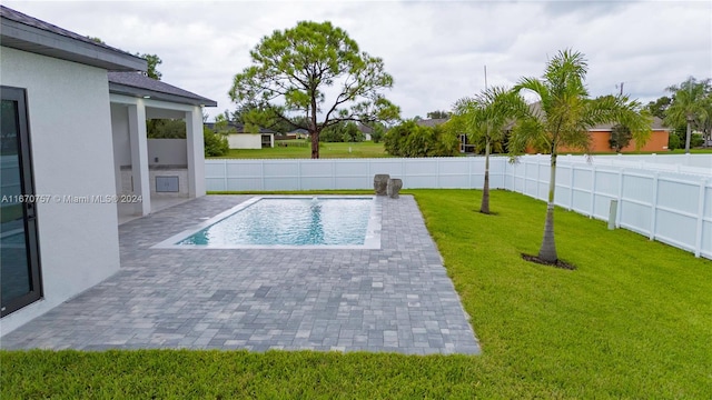 view of swimming pool featuring a lawn and a patio area