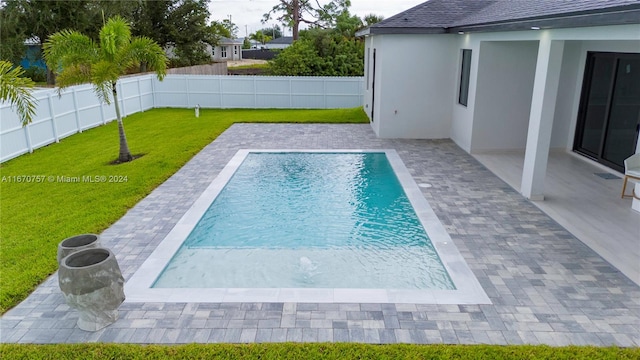 view of swimming pool featuring a yard and a patio area