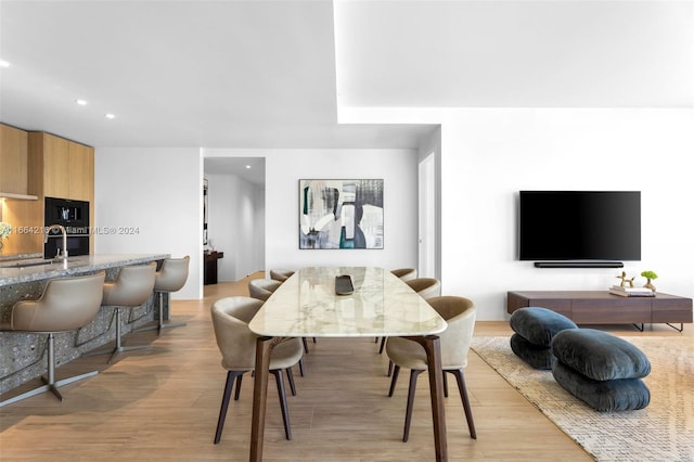 dining space with light hardwood / wood-style floors and sink