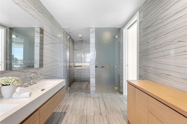 bathroom featuring vanity, tile walls, and a shower with door