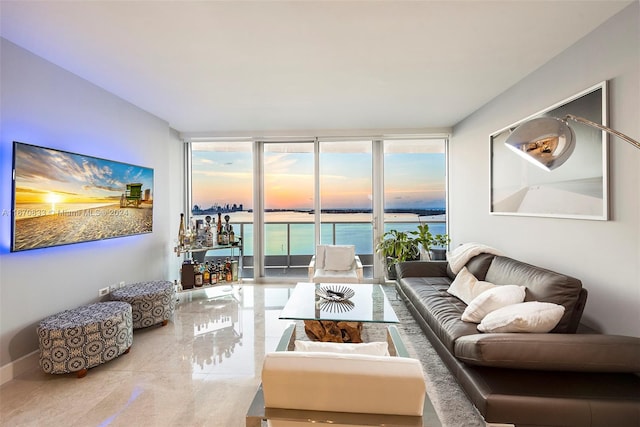 living room featuring floor to ceiling windows and a water view