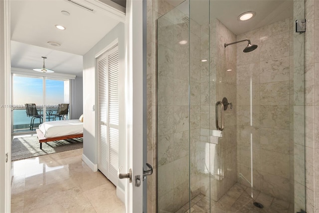 bathroom featuring a shower with door and a water view