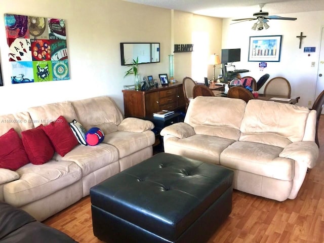 living room with a ceiling fan and wood finished floors