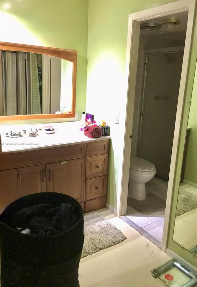 bathroom featuring a stall shower, vanity, and toilet