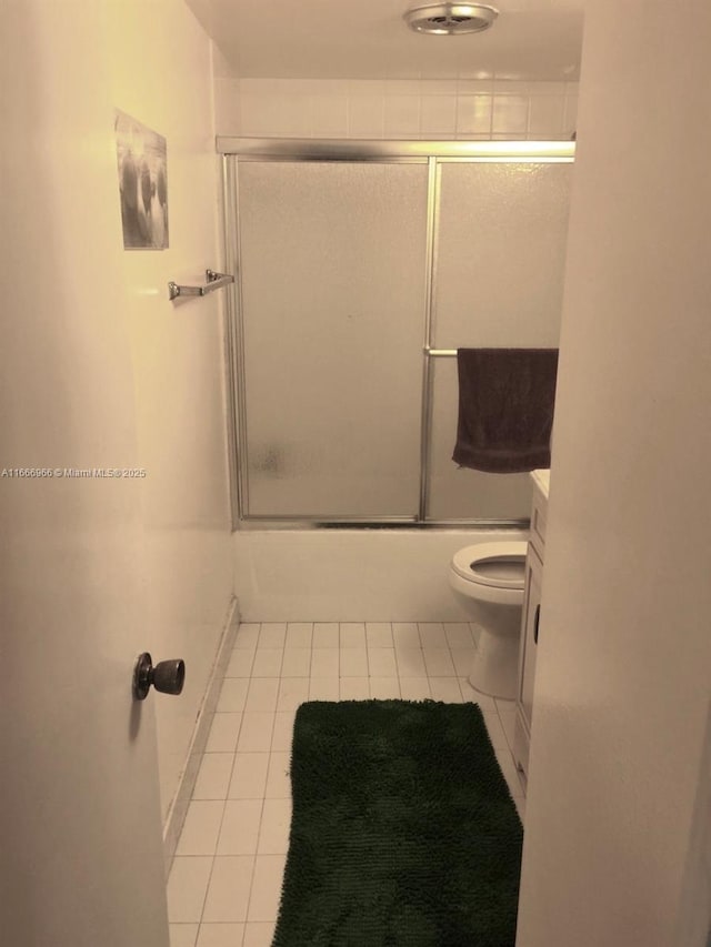 full bath featuring enclosed tub / shower combo, toilet, and tile patterned floors