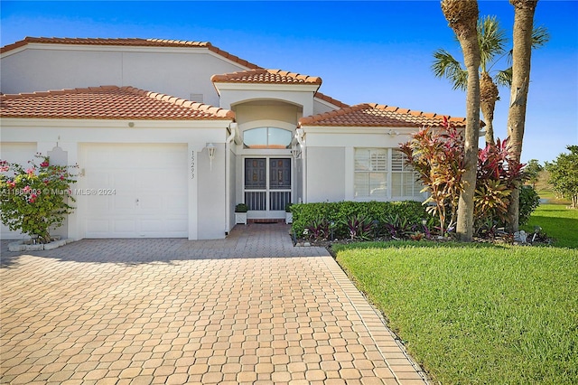 mediterranean / spanish house with a front yard and a garage