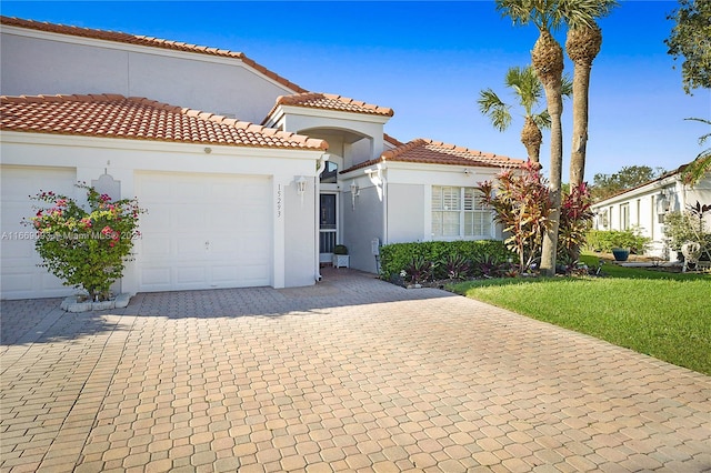 mediterranean / spanish house featuring a garage and a front yard