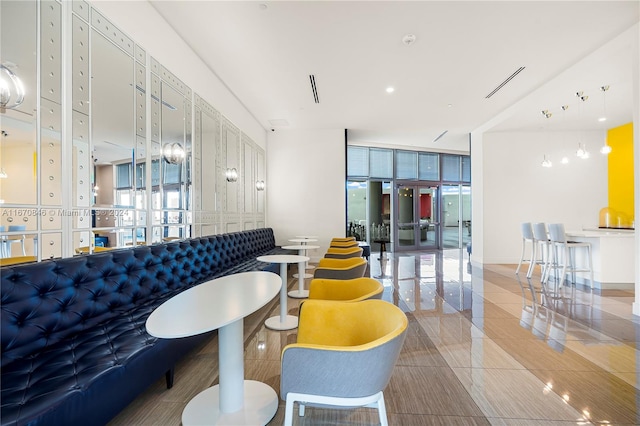 interior space featuring a wall of windows, a healthy amount of sunlight, and tile patterned flooring