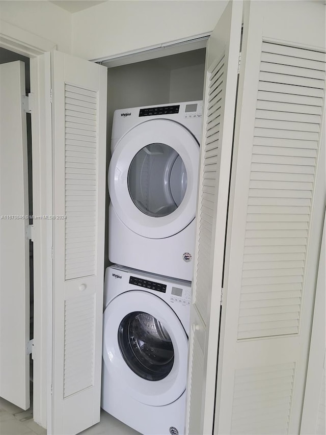 clothes washing area featuring stacked washer and clothes dryer