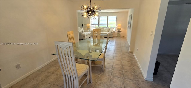 dining space featuring light tile patterned flooring and a chandelier