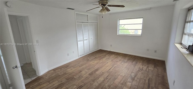 unfurnished bedroom with a closet, wood-type flooring, and ceiling fan