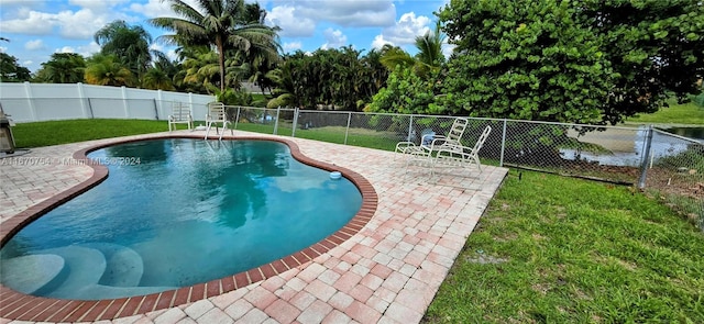 view of swimming pool with a lawn and a patio area